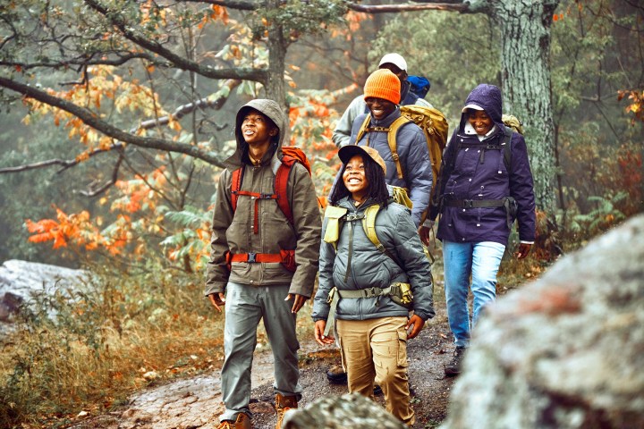 a group of people standing next to a tree