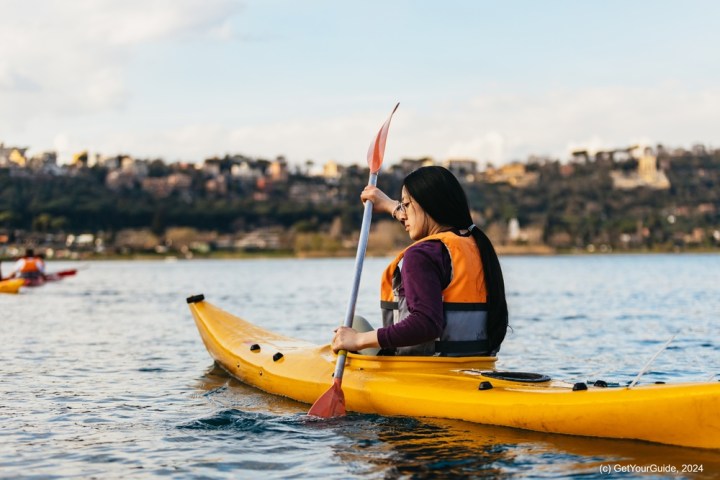 a man riding on the back of a boat in a body of water