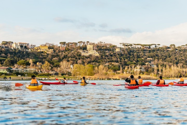 a group of people rowing a boat in a body of water